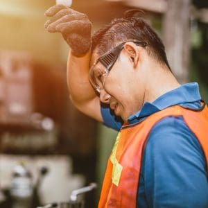 worker wiping brow