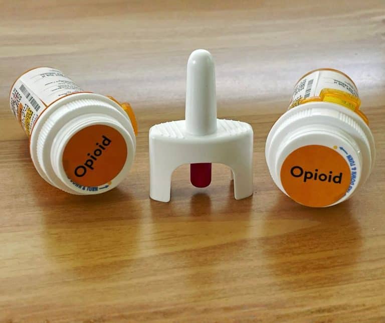 Naloxone spray between two bottles of opioids